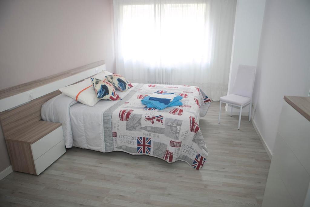 El Apartamento de María في لوغو: غرفة نوم بيضاء بها سرير ونافذة