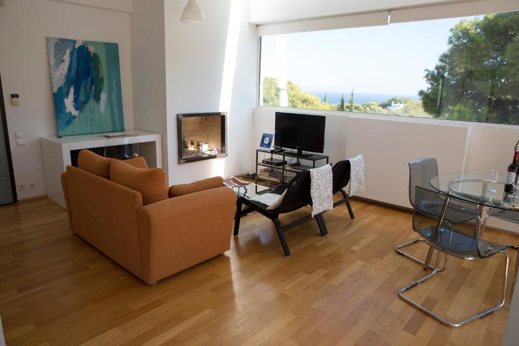 a living room with a couch and a table and a television at Infinity White Complex in Porto Rafti