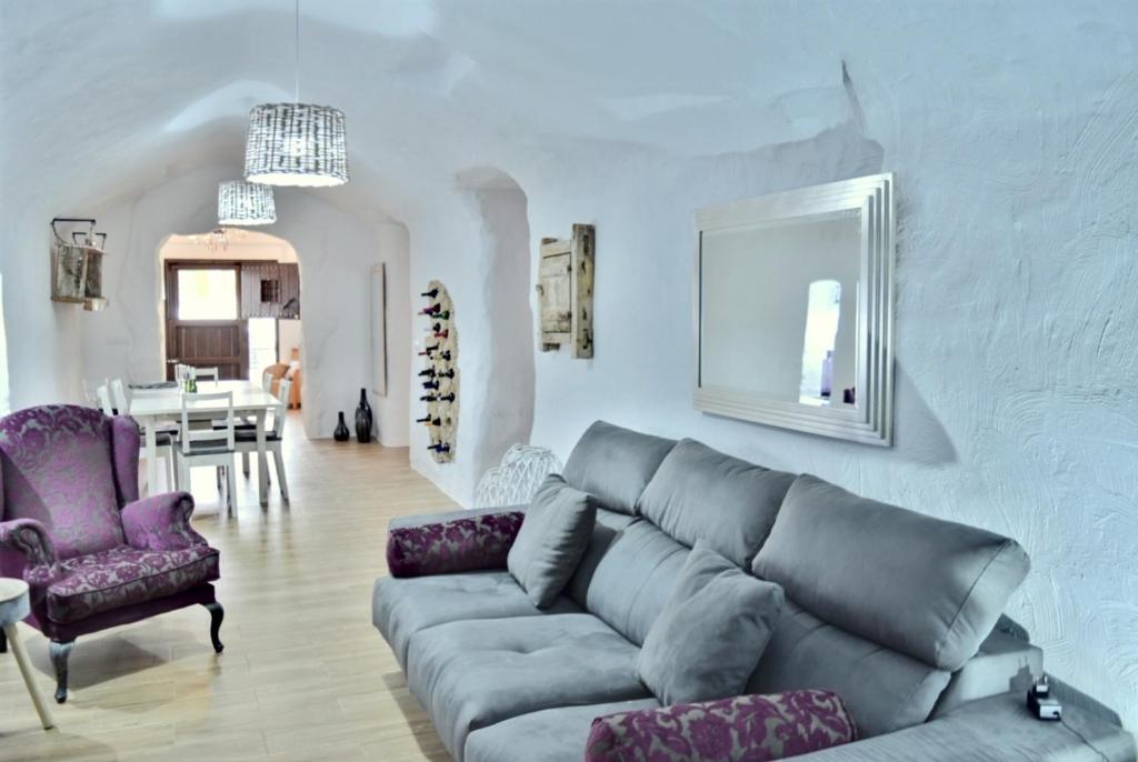 sala de estar con sofá y comedor en Cuevas Helena, en Benamaurel