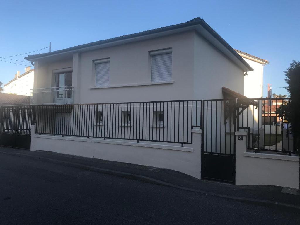 a white house with a fence in front of it at Gite Le Logis Dauphinois in Roussillon en Isere