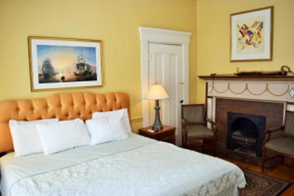 um quarto com uma cama grande e uma lareira em Bellevue House em Newport