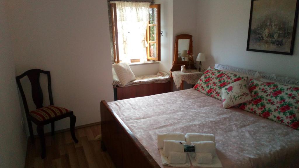 a bedroom with a bed and a chair and a window at Apartments Camellia & Magnolia in Volosko