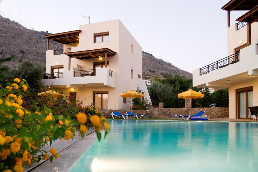 un hotel con piscina frente a un edificio en Blue Dream Luxury Villas en Pefki Rhodes
