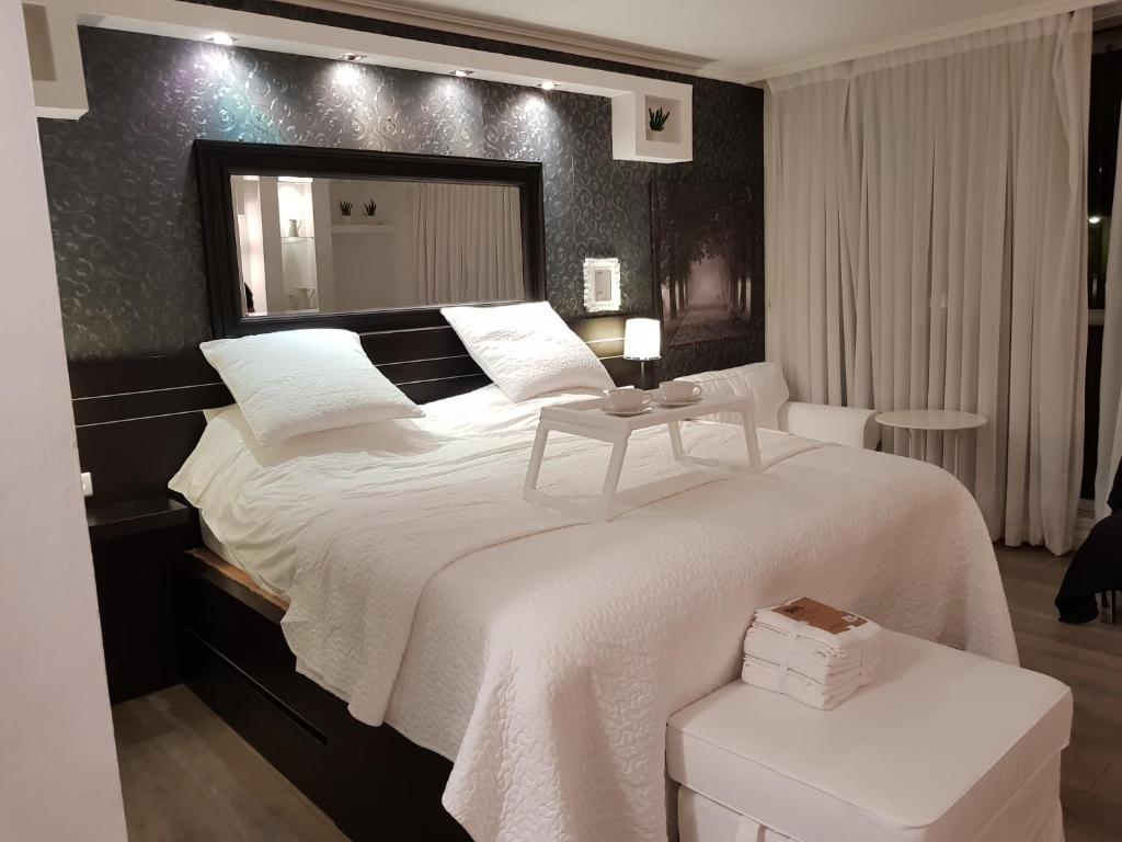 een slaapkamer met een groot bed en een grote spiegel bij Cosy Studio in a Luxury Hotel in Herzelia 