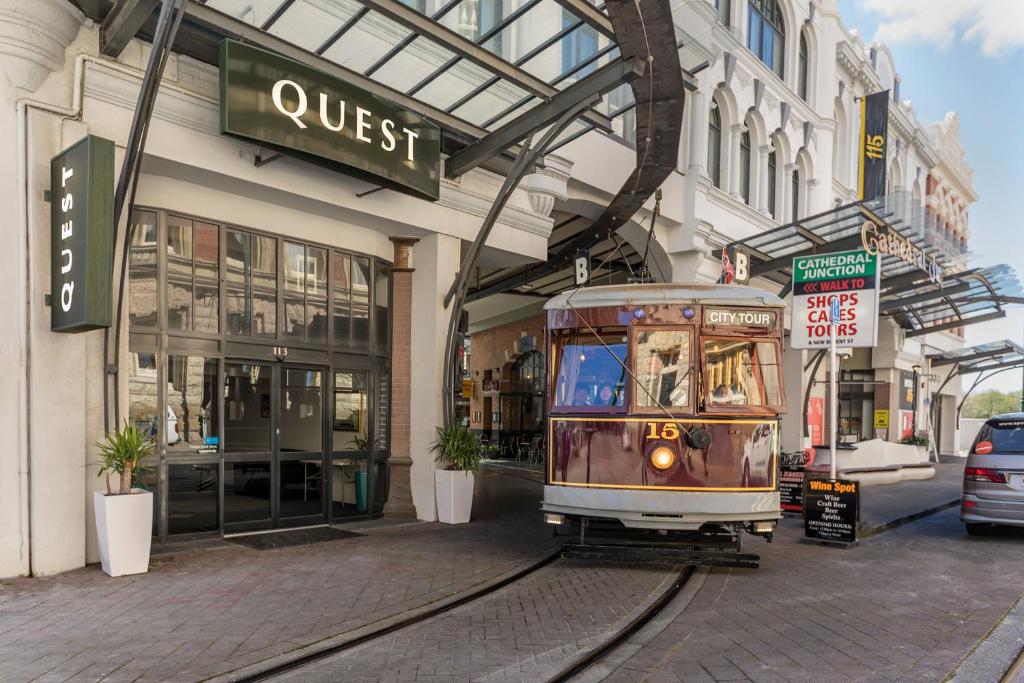 un tram in una strada di fronte a un edificio di Quest Cathedral Junction Serviced Apartments a Christchurch