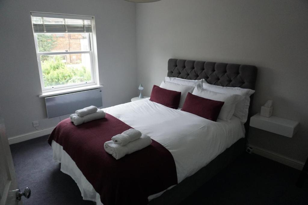 3 Summertown Court في أوكسفورد: غرفة نوم بسرير كبير عليها منشفتين