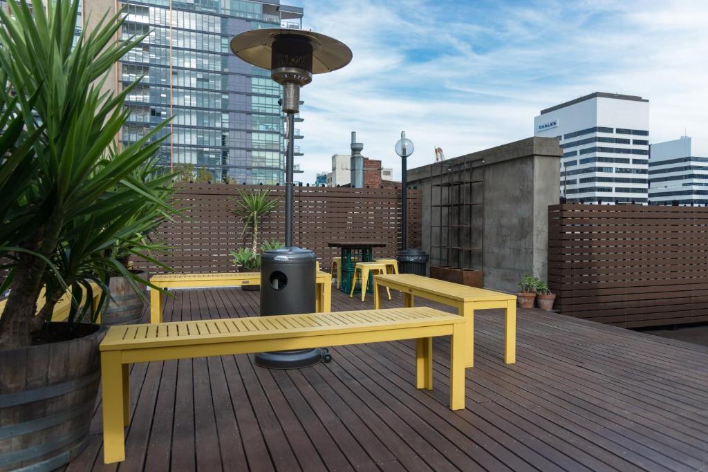 a yellow bench on top of a deck with buildings at Best Western Melbourne City in Melbourne