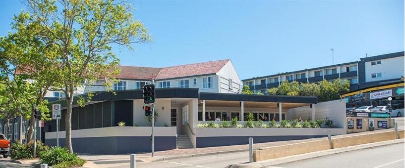 a building on the corner of a street with a traffic light at Seabreeze Hotel in Nelson Bay