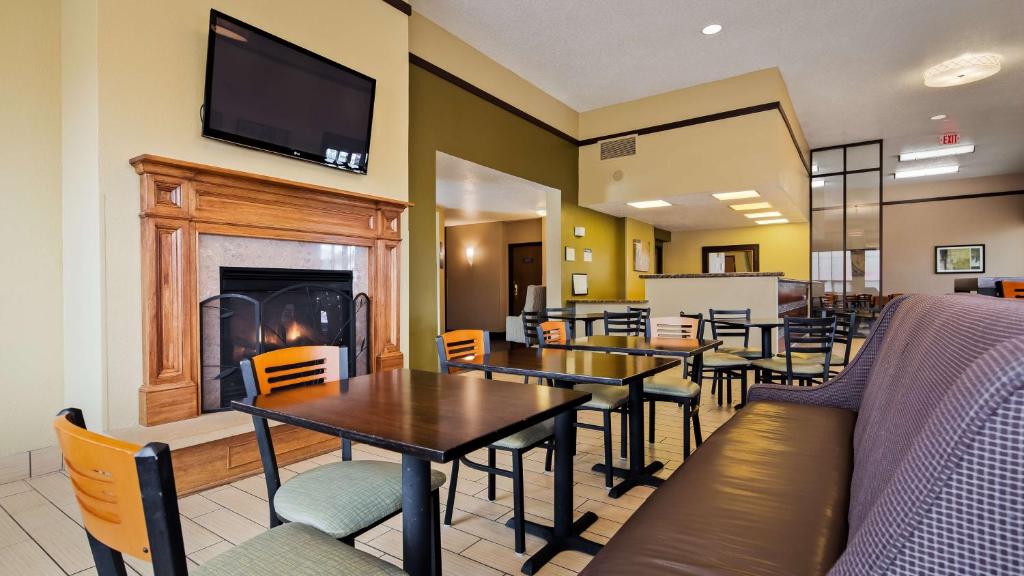 a dining room with tables and a fireplace at Best Western Ambassador Inn & Suites in Wisconsin Dells