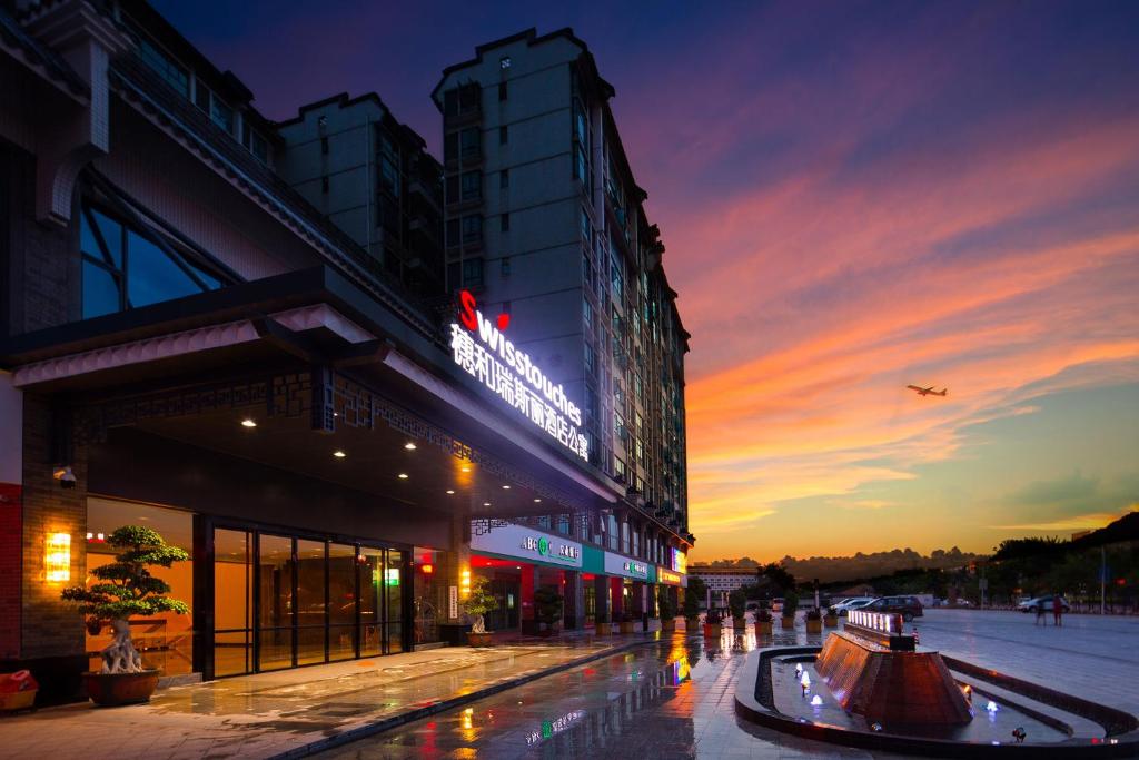 een gebouw met 's nachts een bord bij Swisstouches Guangzhou Hotel Residences in Guangzhou