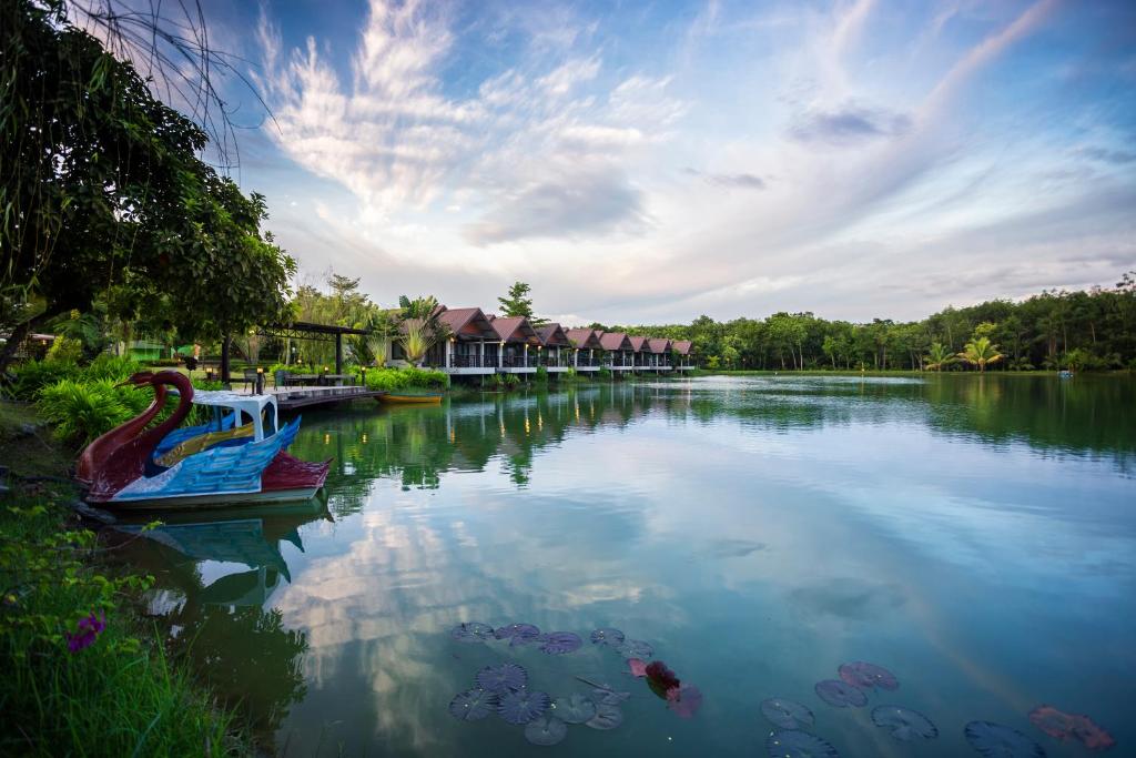 a river with two boats in the middle at Tamali Hotel in Nakhon Si Thammarat