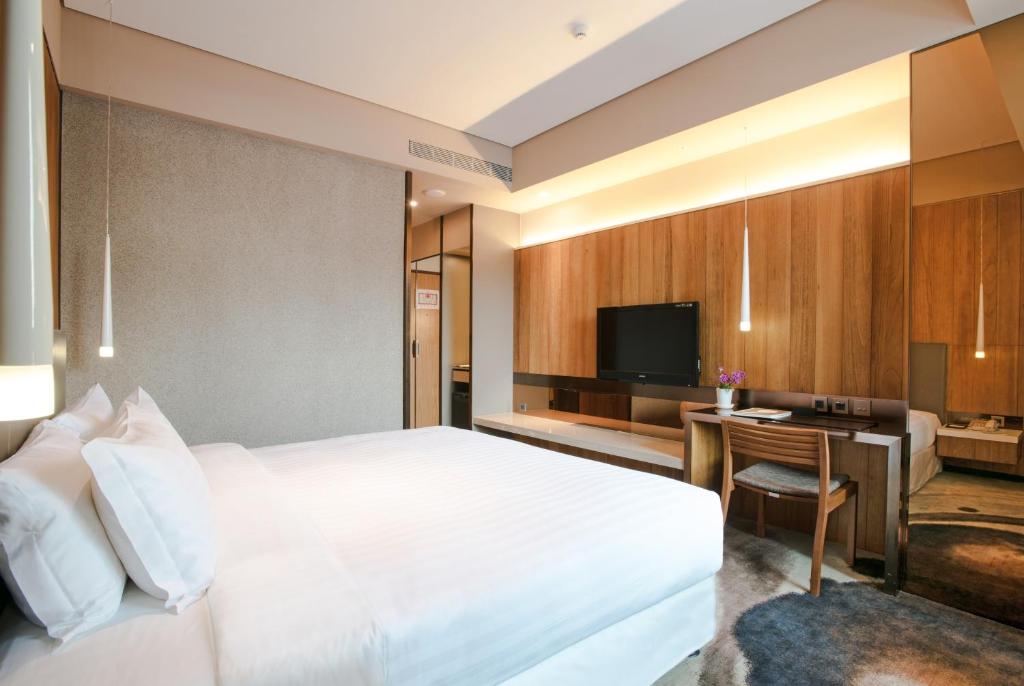 a bedroom with a bed and a desk and a television at Home Hotel in Taipei