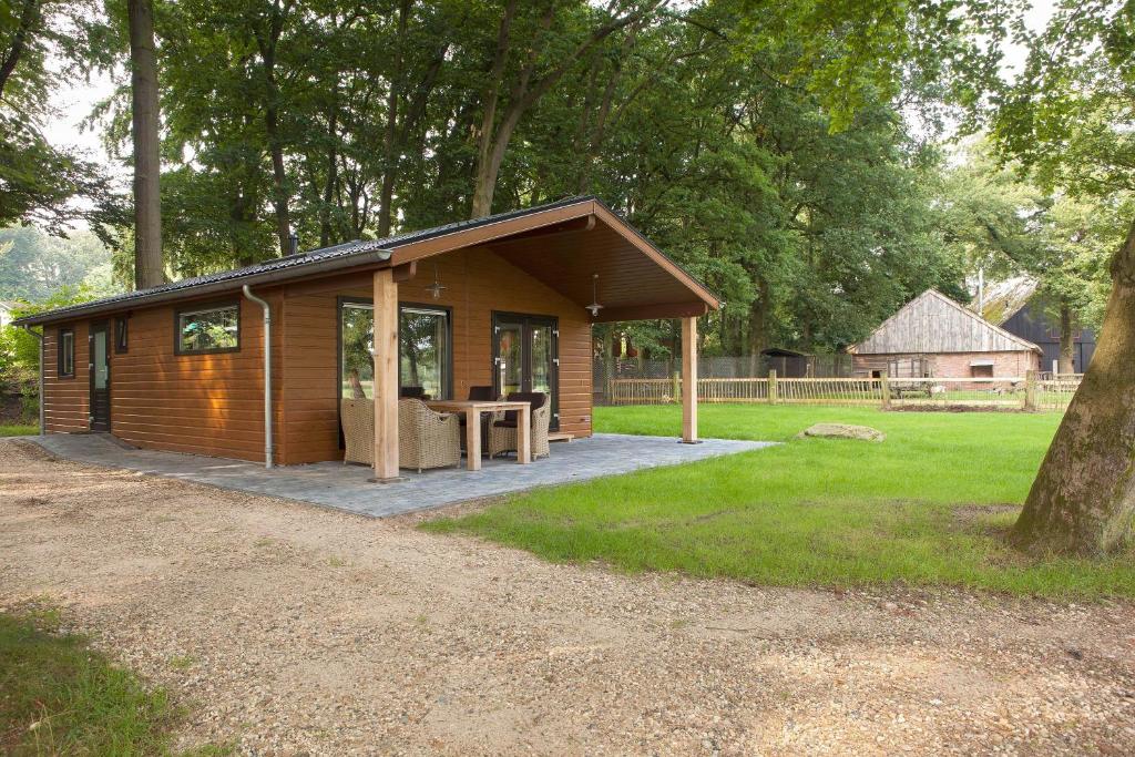 een kleine houten hut met een picknicktafel in een veld bij Hoeve Springendal Erf&Bron in Hezingen