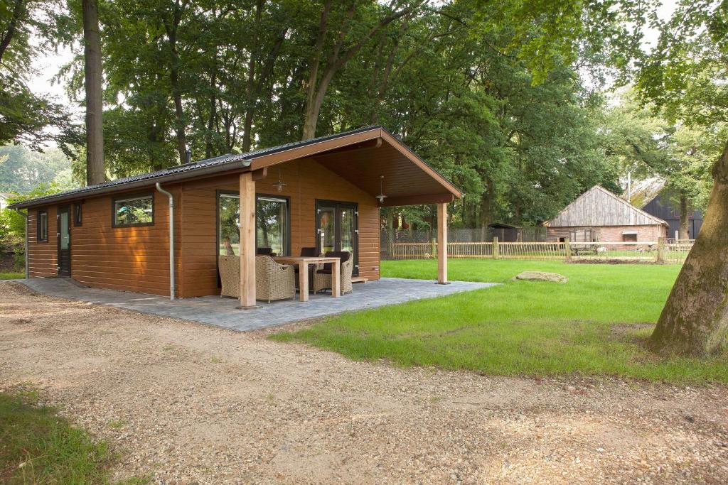 a small wooden cabin with a picnic table in a field at Hoeve Springendal Erf&Bron in Hezingen
