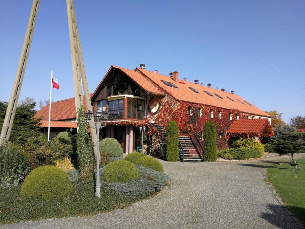 una casa con techo rojo y un patio con arbustos en Podkowa Modliszów, en Modliszów