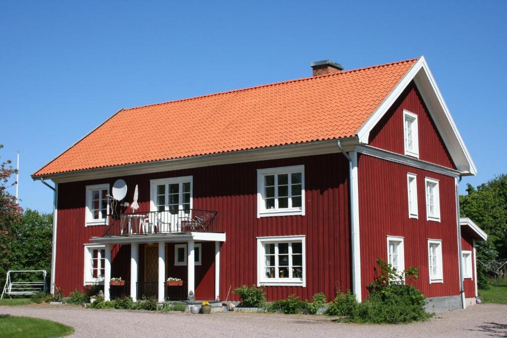 een rode schuur met een oranje dak bij Fagerlid Gård in Hova