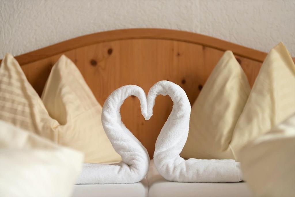 due cigni per asciugamani seduti su un letto con cuscini di Appartements-Restaurant Schwaiger a Tauplitz