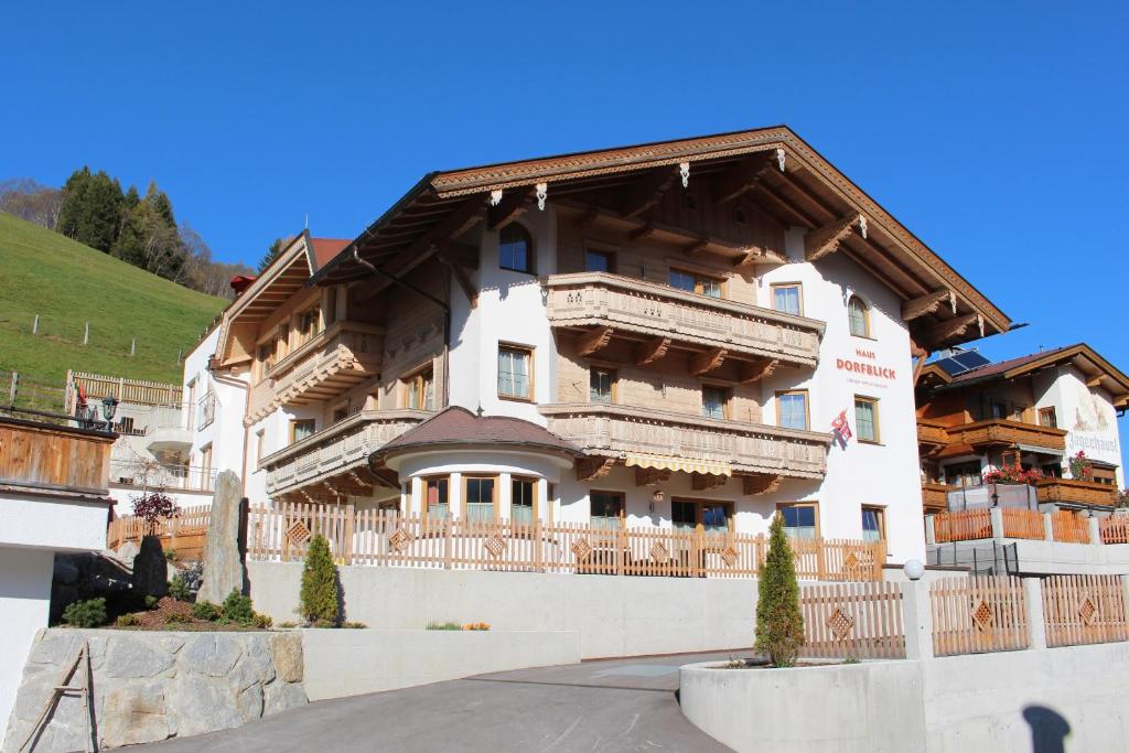 ein großes Gebäude mit einem Holzdach in der Unterkunft Haus Dorfblick in Gerlos