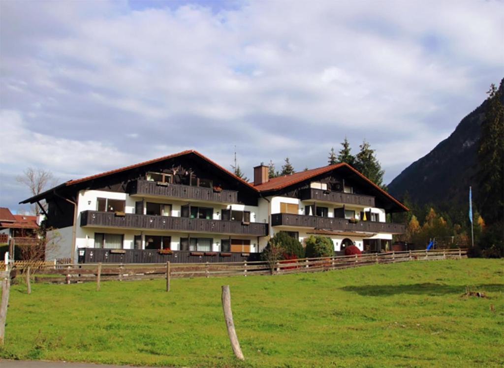 a large building in a field in front of a mountain at Farchanter Alm in Farchant