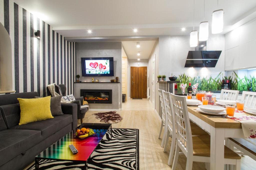 une cuisine et un salon avec un canapé et une table dans l'établissement Apartament PAJO II -Rezydencja Tatry--GROTA SOLNA--BALKON--PARKING, à Zakopane
