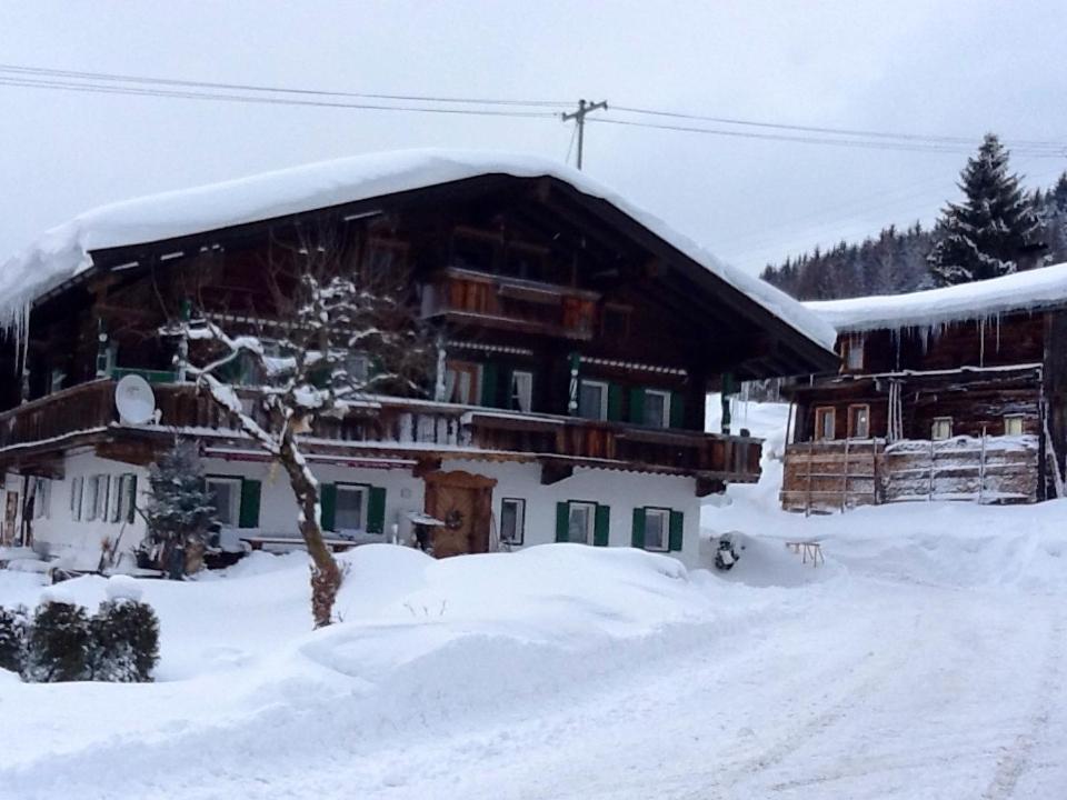 a snow covered house with a snow covered roof at Branderhof in Jochberg