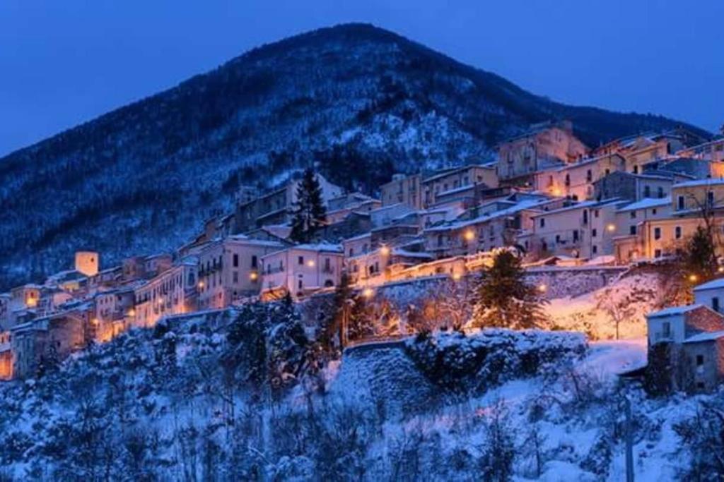 eine Stadt auf einem Hügel im Schnee in der Nacht in der Unterkunft Casa Vacanze sul Gizio in Pettorano sul Gizio