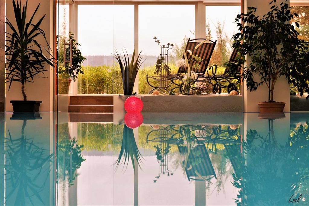 Habitación con piscina con plantas y ventana en Flairhotel am Wörthersee en Schiefling am See