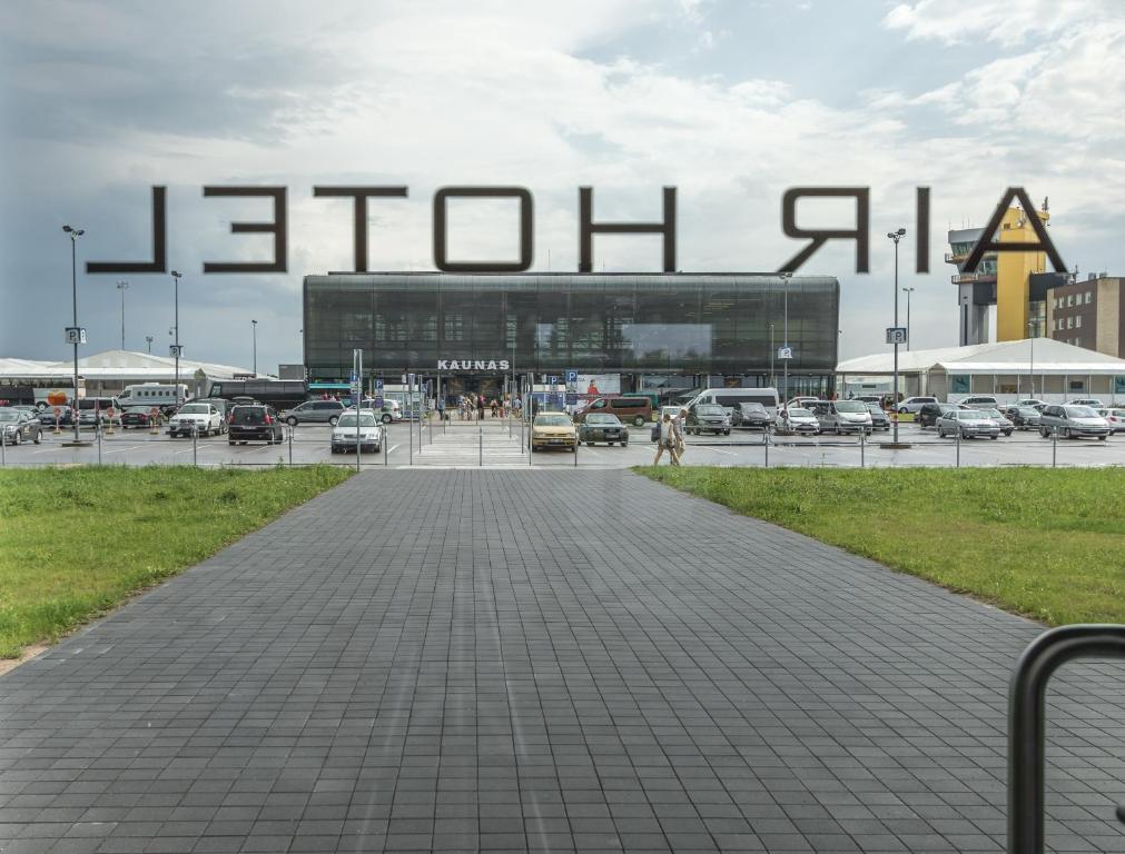 a parking lot with a large sign in front of a building at Air Hotel in Karmėlava