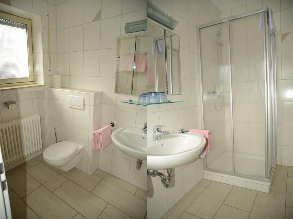 ein weißes Bad mit einem Waschbecken und einem WC in der Unterkunft Hotel Leise Garni in Willingen