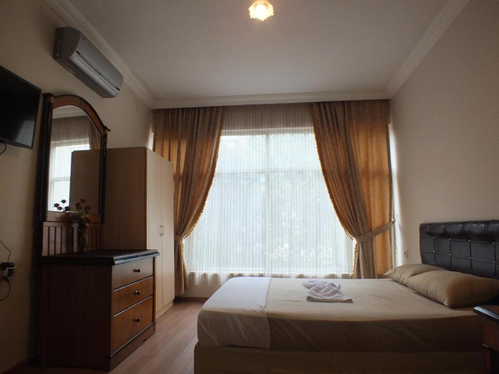 um quarto com uma cama e uma grande janela em Uyar Palace em Antalya