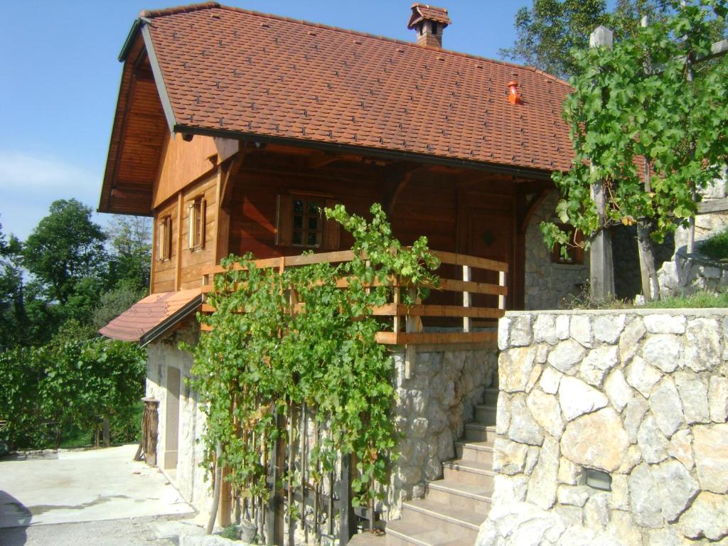 uma casa com uma parede de pedra e uma cerca em Zidanca med Vinogradi em Otocec