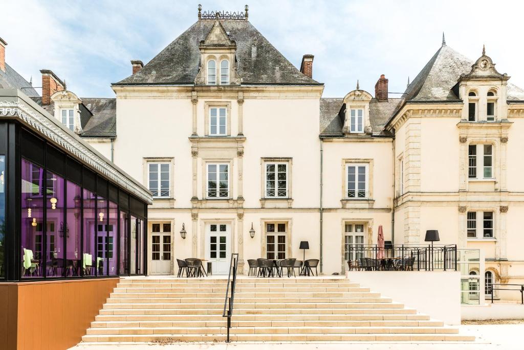 um edifício antigo com escadas em frente em Le Mans Country Club em Yvré-lʼÉvêque