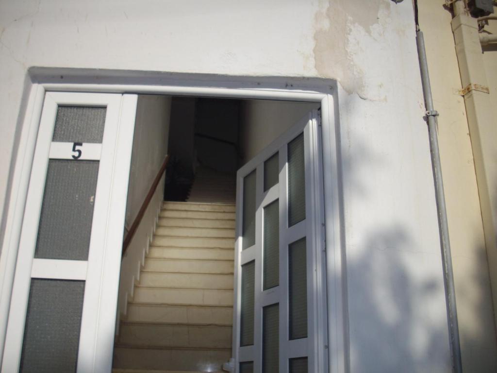 an open door leading to a stairwell with stairs at Anna in front of the sea Apartment in Sitia