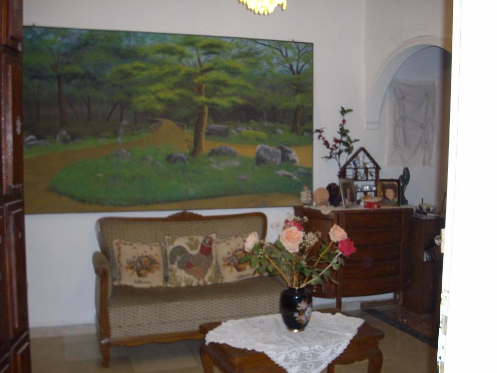 a living room with a couch and a painting on the wall at Anna in front of the sea Apartment in Sitia
