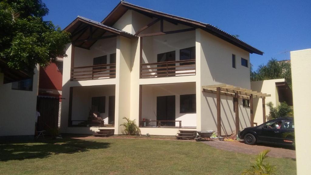 een wit huis met een auto ervoor geparkeerd bij Studios Formanabá in Florianópolis