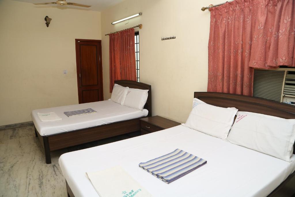 een kamer met 2 bedden en een raam bij Star Residency in Chennai
