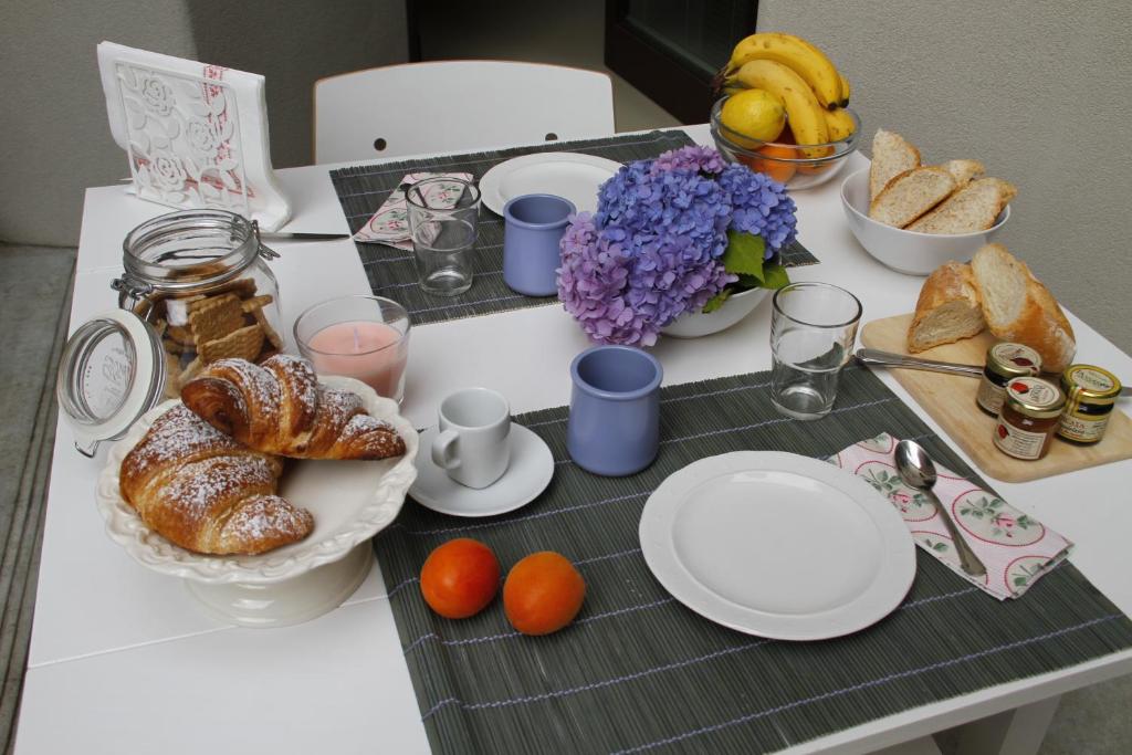 a table with plates and bread and fruit on it at La Salvia e Il Lampone in Pove del Grappa