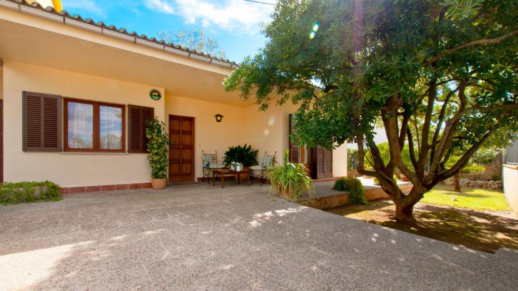 a house with a tree in front of it at Casa CORA Alcudia in Port d'Alcudia