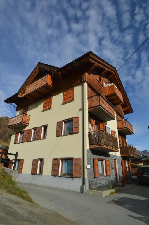 un edificio con balcones de madera en un lateral en Fior d'Alpe Apartment en Livigno