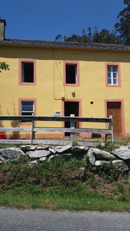 a yellow building with a fence in front of it at Casa Polo in Loiba