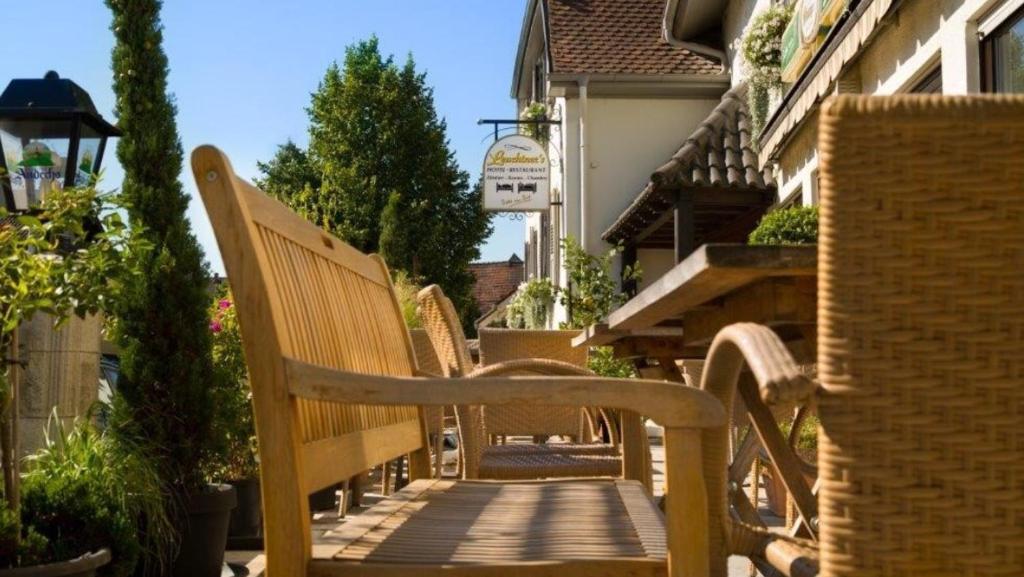 a row of wooden benches sitting on a walkway at Leuchtners an der Rennbahn in Iffezheim