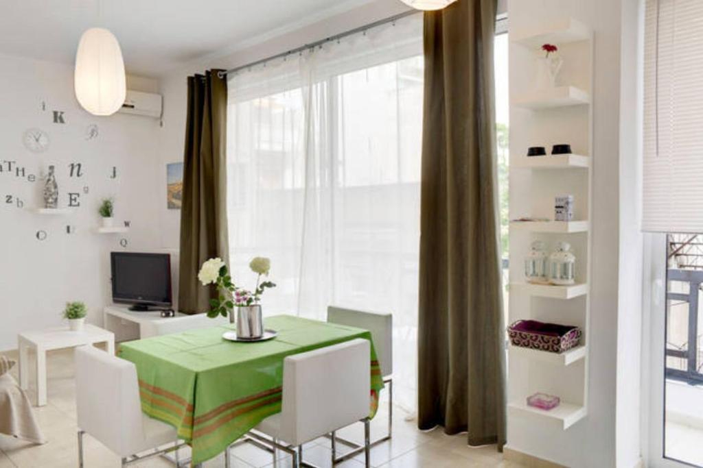 jadalnia z zielonym stołem i białymi krzesłami w obiekcie Thelma's Apartment w Atenach