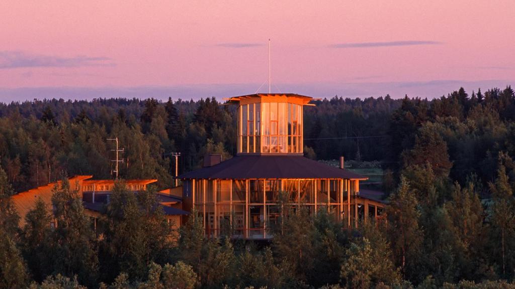 a building with a tower in the middle of a forest at Hotelli Liminganlahti in Liminka