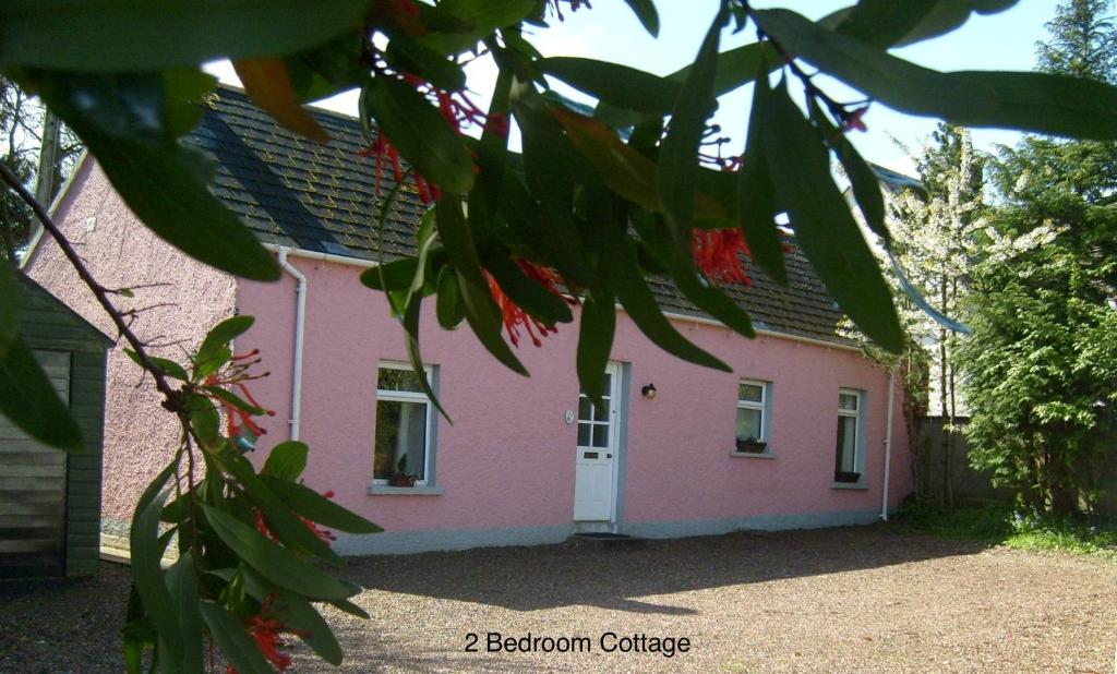 ベルファストにあるHallmount Cottage - Belfastの白い扉付きピンクの家