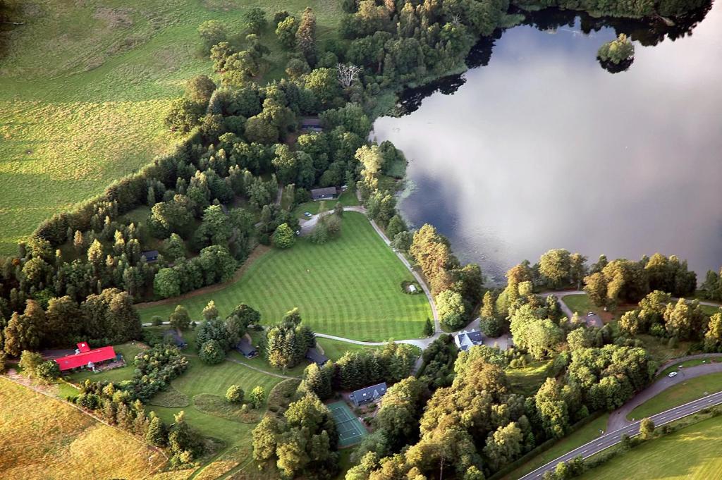 an aerial view of a house and a lake at Loch Monzievaird Chalets in Crieff