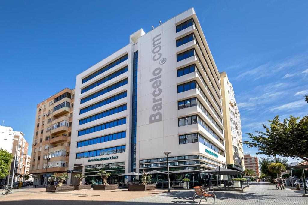 un gran edificio blanco con un cartel. en Occidental Cádiz, en Cádiz