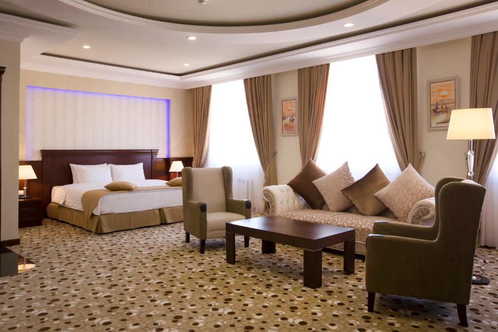 a hotel room with a bed and a couch and a table at Central Hotel Yerevan in Yerevan