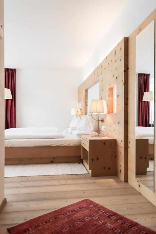 Postel nebo postele na pokoji v ubytování Alpine Hotel Ciasa Lara