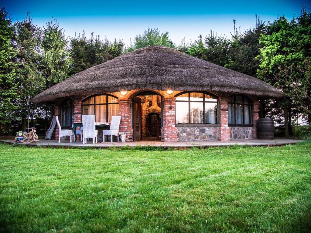 Cabaña con mesa y sillas en un patio en Agroturystyka u Karoliny, en Sarbinowo