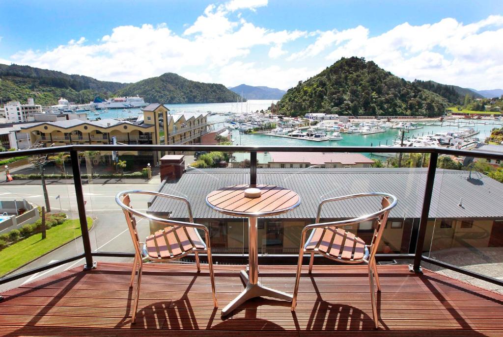 uma mesa e cadeiras numa varanda com vista para um porto em Harbour View Motel em Picton